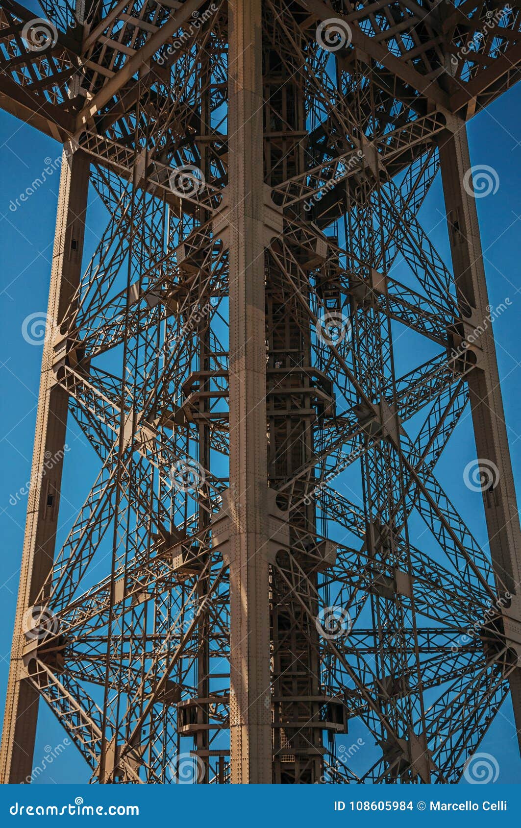 view of one legÃ¢â¬â¢s iron structure of the eiffel tower, with sunny blue sky in paris.